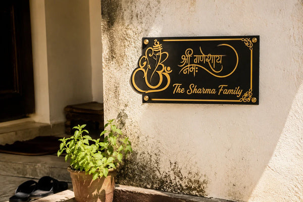 Ganesha acrylic name plate mounted on an Indian home entrance wall facing East in morning sunlight