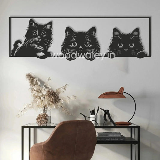 Handcrafted wooden wall decor with three black cat silhouettes above a modern desk setup