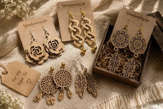 Personalized wooden earrings with floral cutout designs laid out on a woven cloth