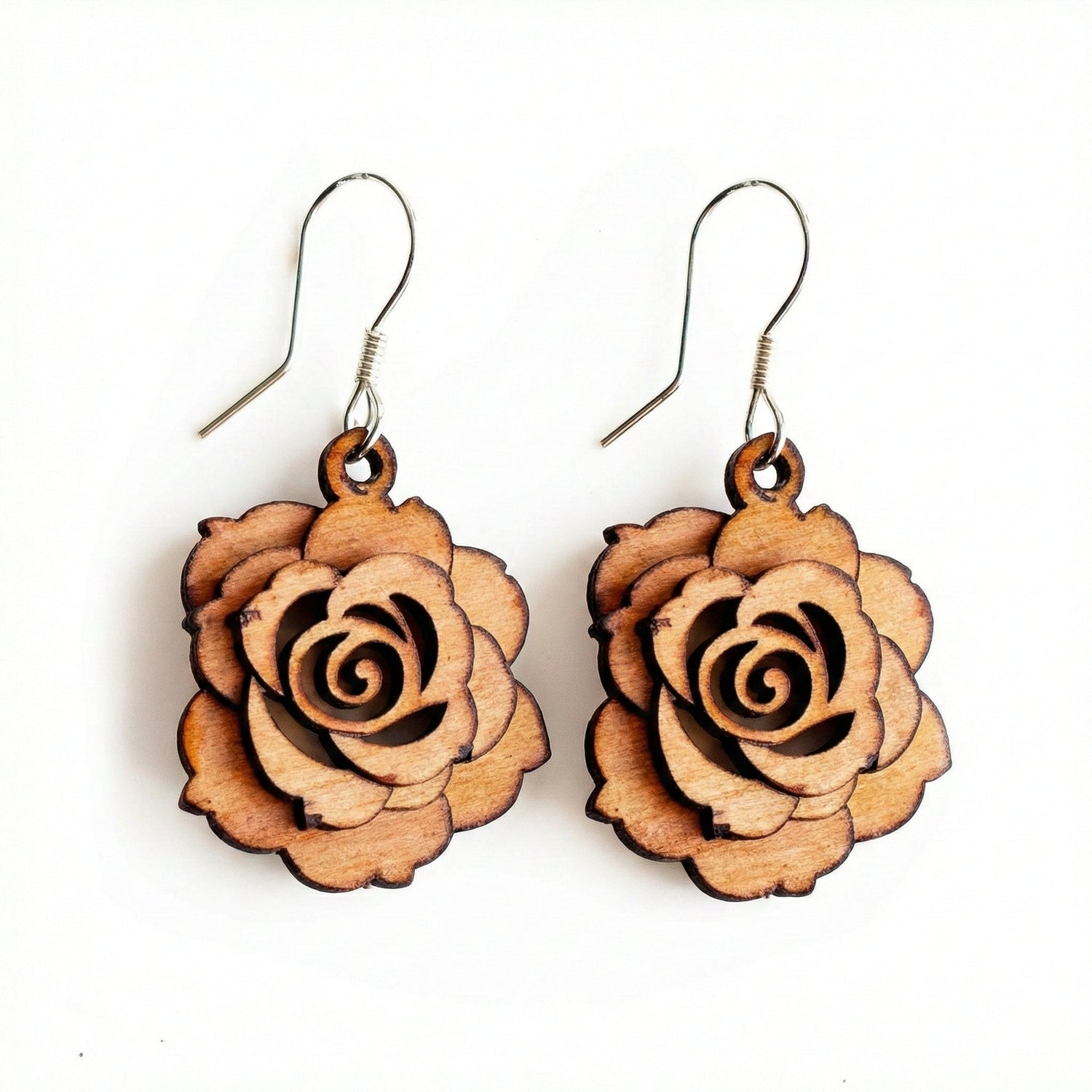 Woman wearing large handcrafted wooden earrings with intricate cutout design