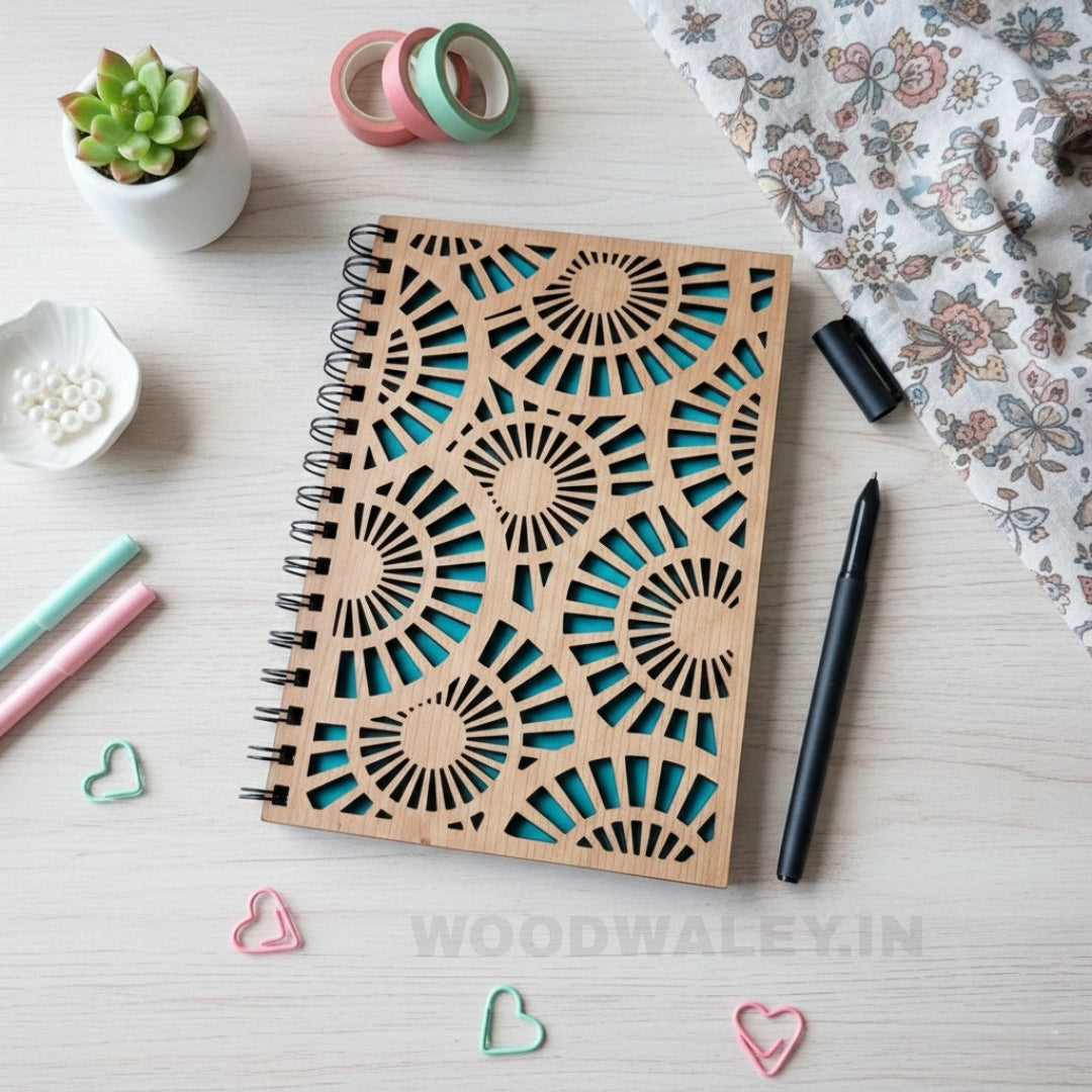 Wooden notebook with decorative cut-out design on a light surface with stationery items.