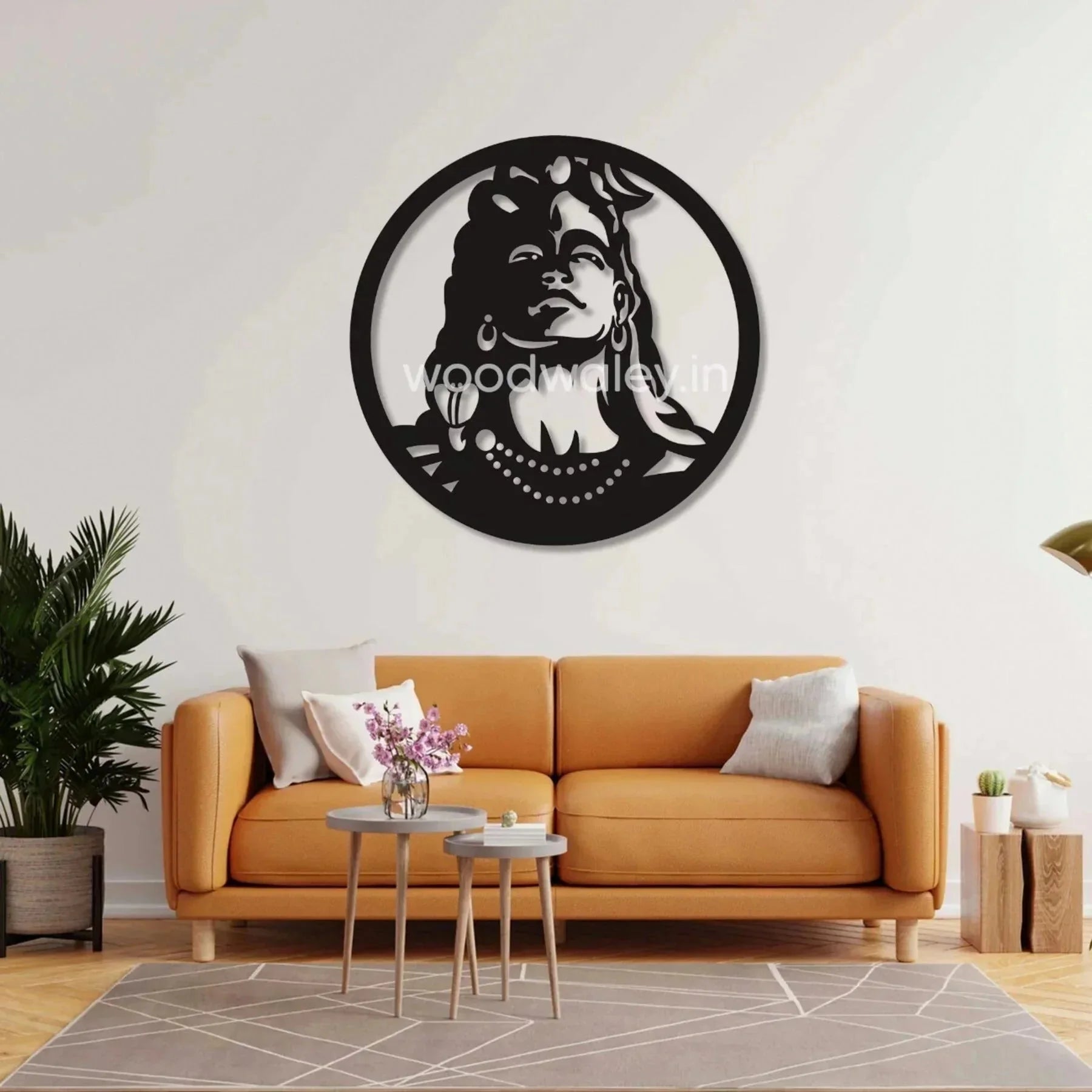 Laser-cut wooden Shiva wall art above modern orange sofa in living room with plants