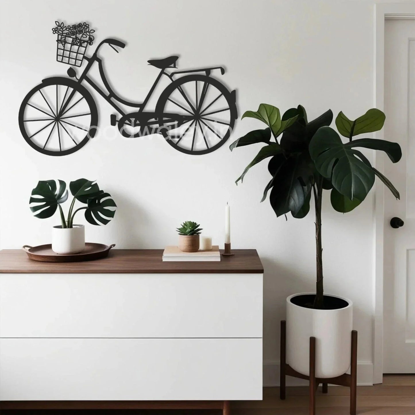 Modern living room with a black bicycle wall art, white sideboard, and potted plants decor.